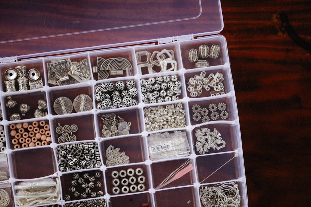 A close-up view of a neatly organized box filled with diverse crafting beads in compartments.