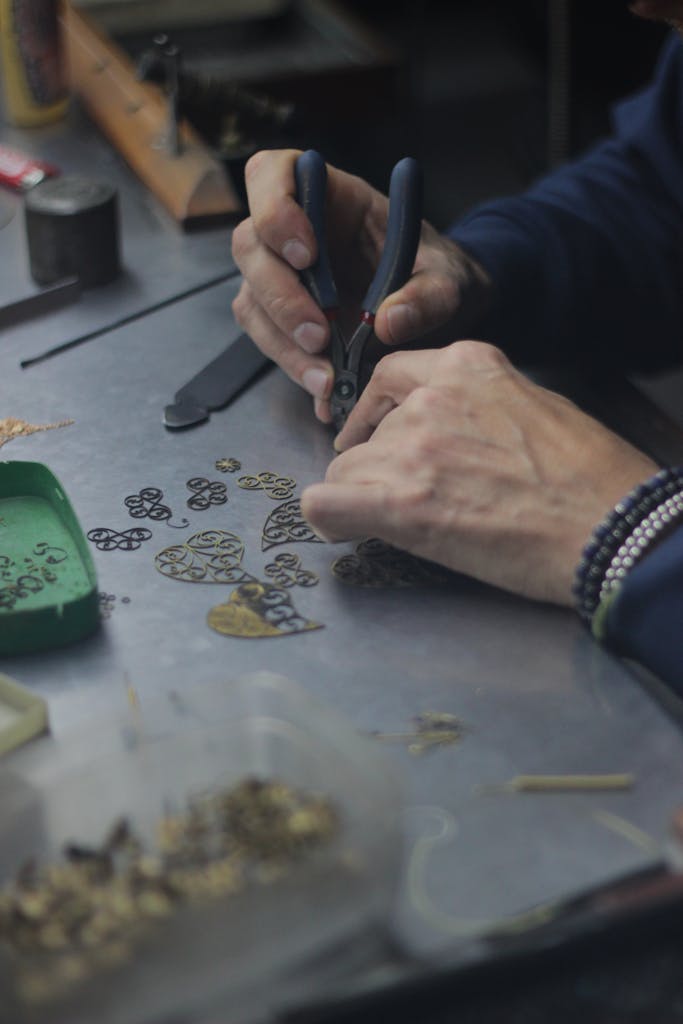 Close-up of an artisan's hands designing gold jewelry in Guimarães, Portugal.
